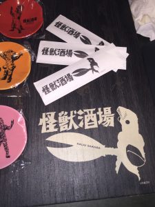 【怪獣酒場】メニューと箸袋。写真左に映っている小皿はお土産用でくれた小皿です。
